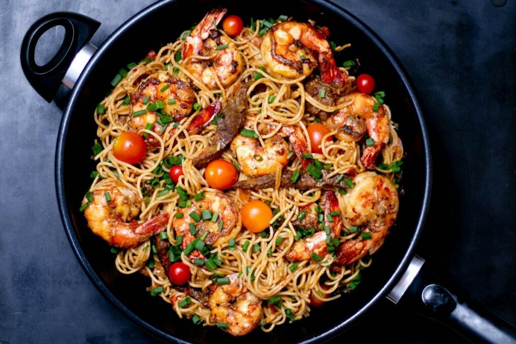 Menu Spaghetti with shrimp and cherry tomatoes in a pan