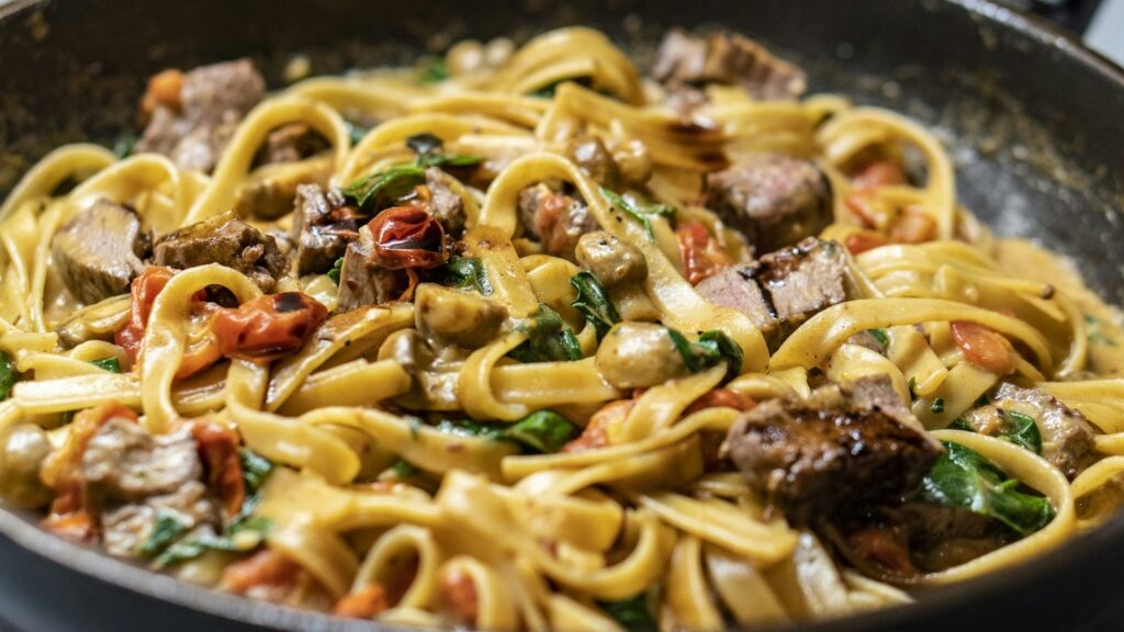 Tagliatelle mit Pilzen und Rahmsauce in der Pfanne