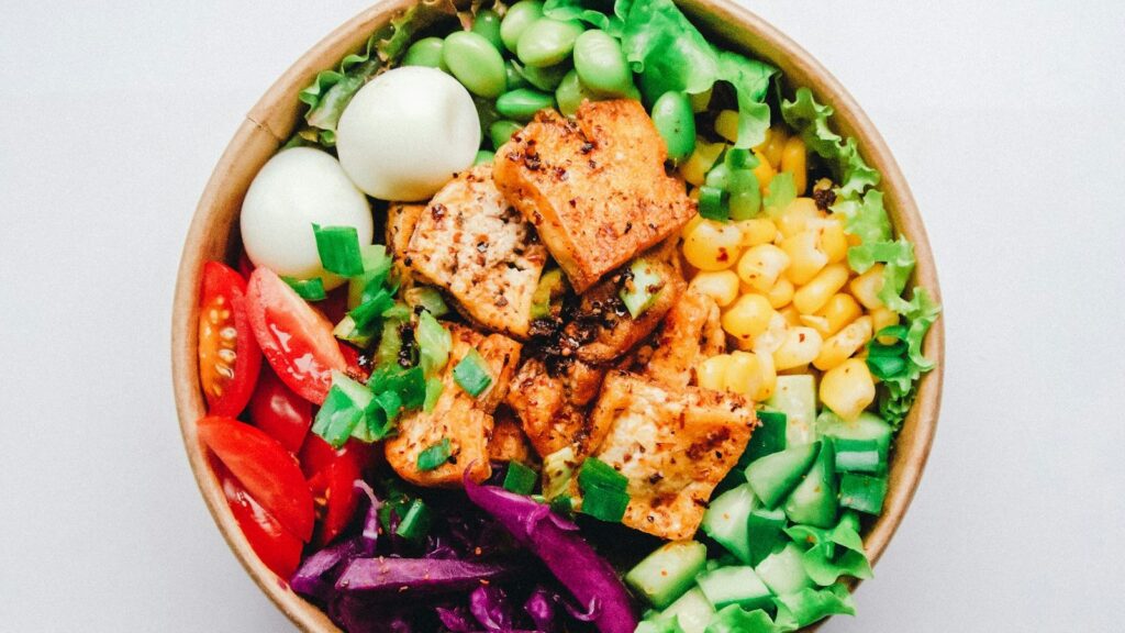 Menu Colorful salad with egg, tomatoes, sweet corn and salmon in a bowl