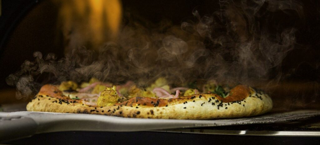 Menu Pizza in the stone oven over glowing heat